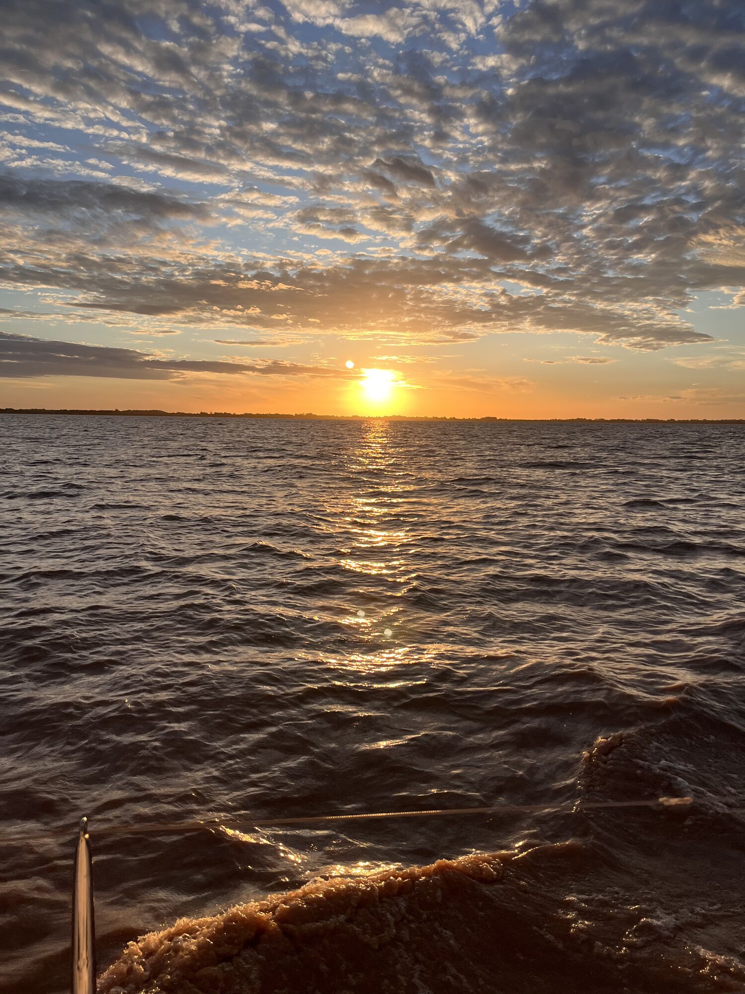 Nicolás mirando la puesta de sol sobre el Río de la Plata desde la orilla